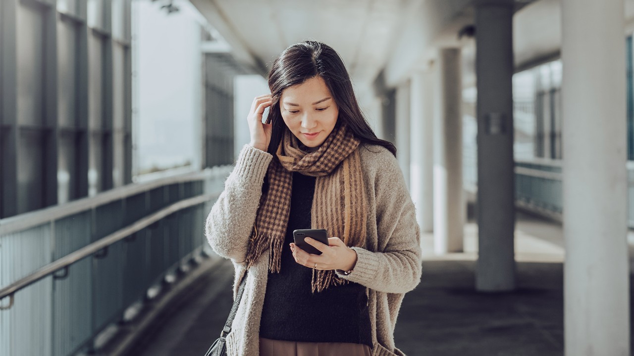 A woman is looking at her mobile phone; image used for HSBC Malaysia manage existing debt article page.