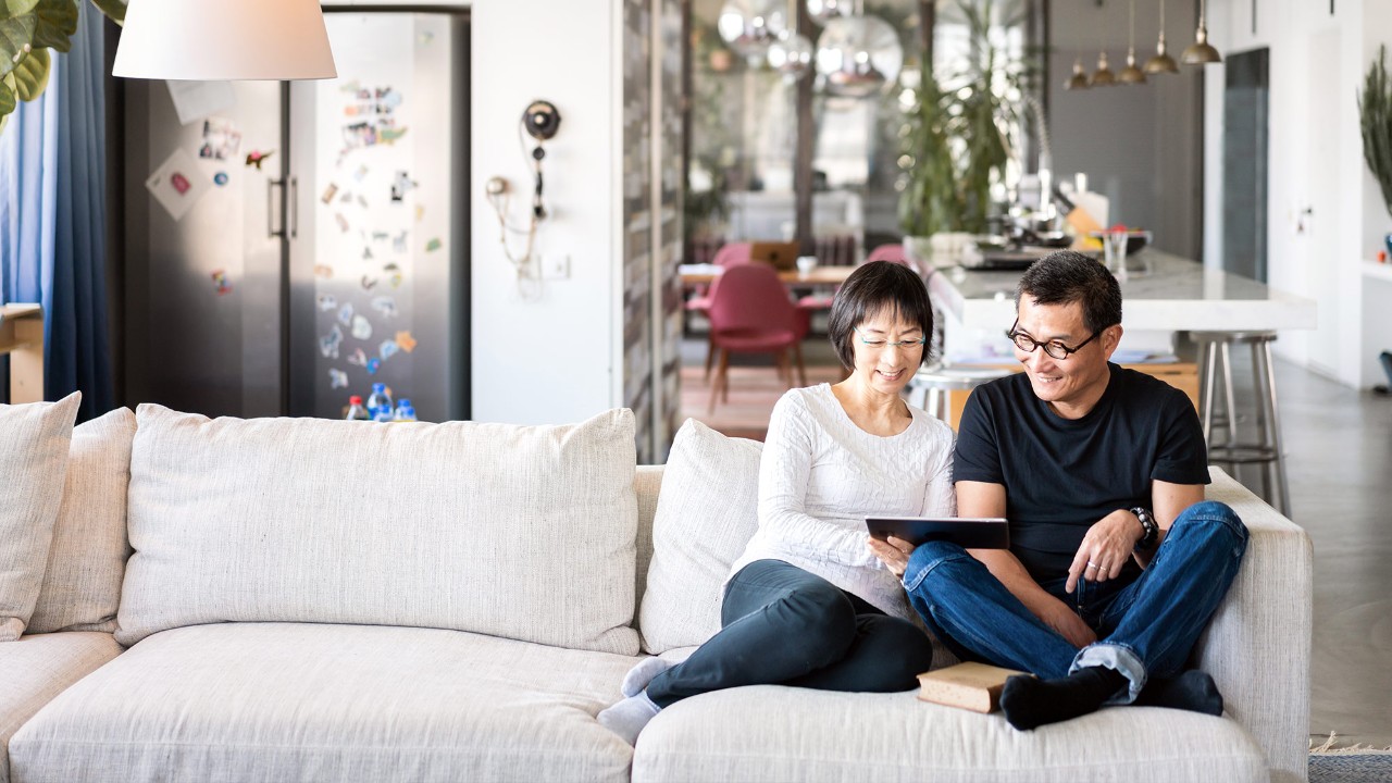 A couple is using tablet in the living room ; image used for HSBC Malaysia save for the future article page.