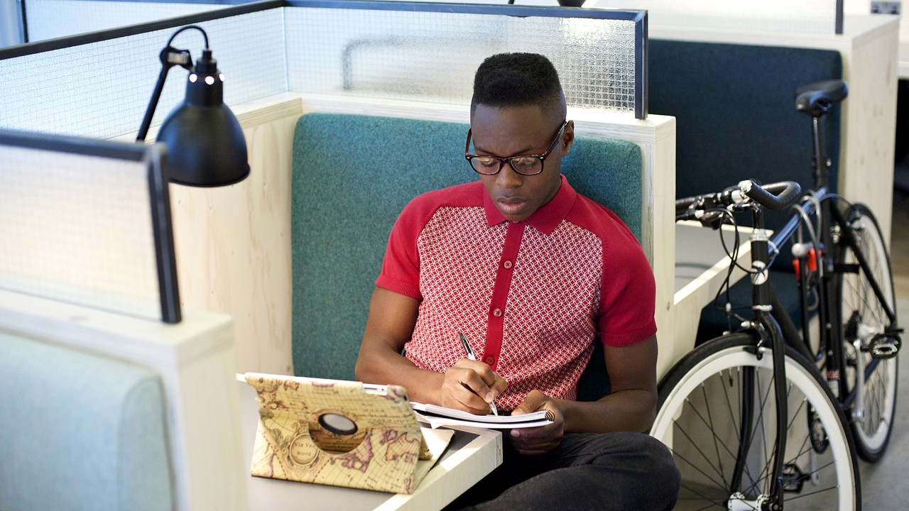 A man is studying and taking notes in a library; image used for HSBC Malaysia habits for financial wellbeing article page.