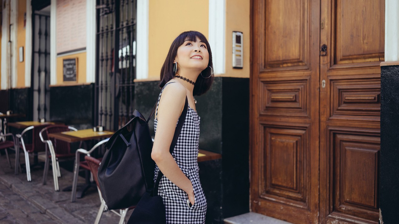 A girl is looking up and smiling on the street; image used for HSBC Malaysia free up funds article page.