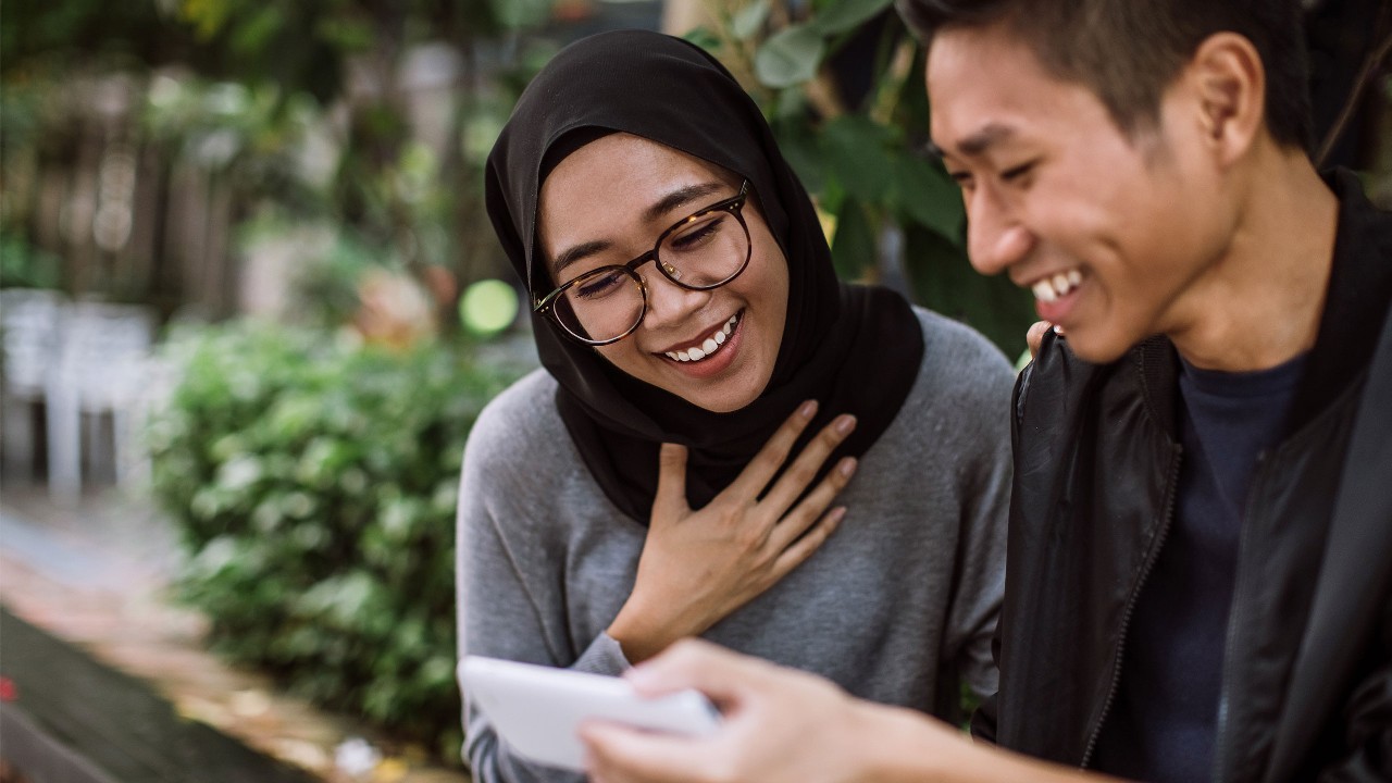 A man and woman are using a tablet; image used for HSBC Malaysia mobile banking