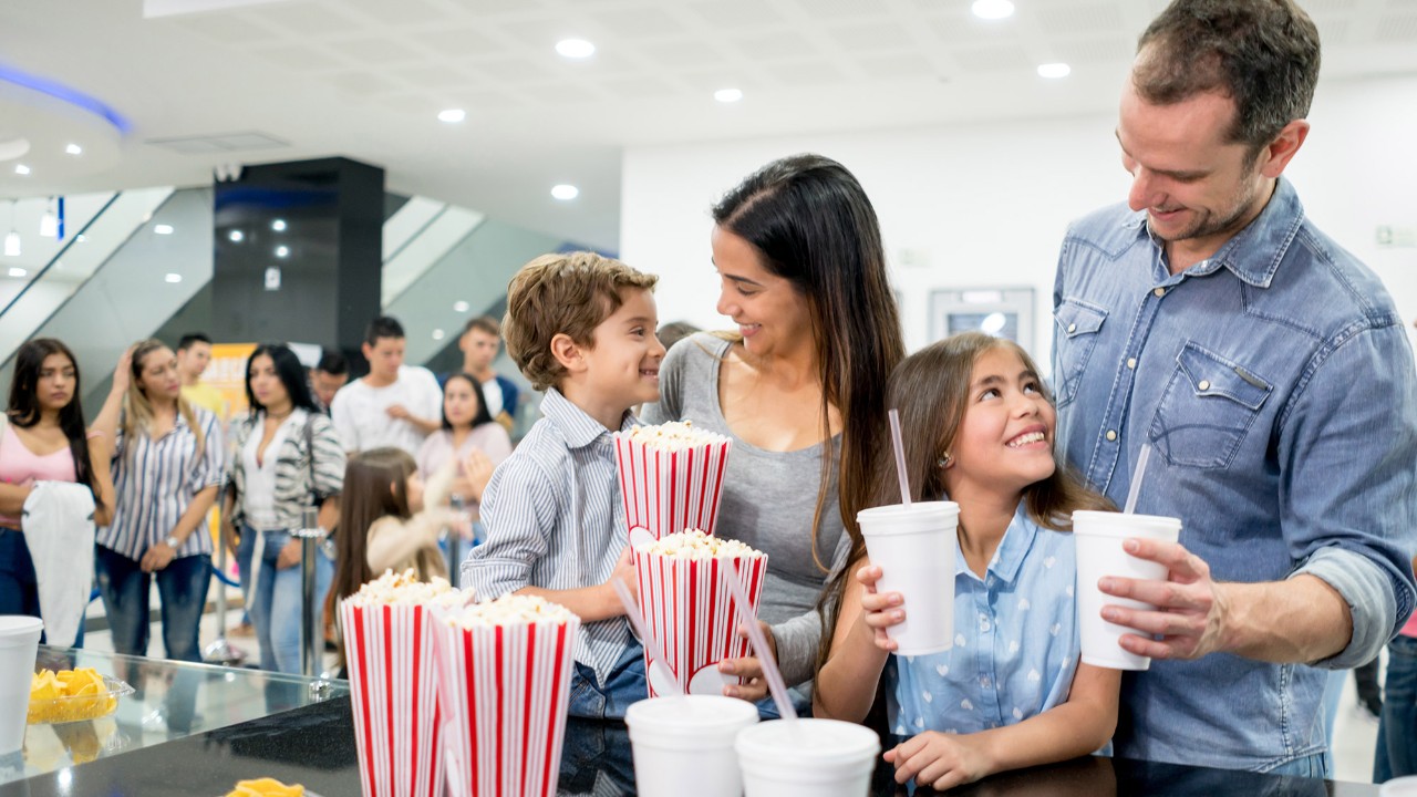Family with popcorn at the cinema; image used for HSBC Rewards program page.