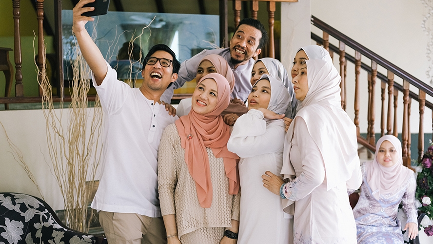 A family is taking a picture together; image is use for HSBC Malaysia Got a Big Hari Raya Credit Card Bill article