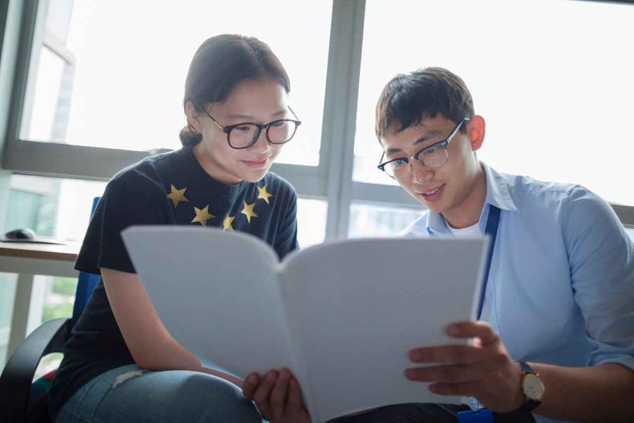 A man and woman are looking at papers; image used for HSBC Malaysia Premier Education Help Your Children Study Abroad article