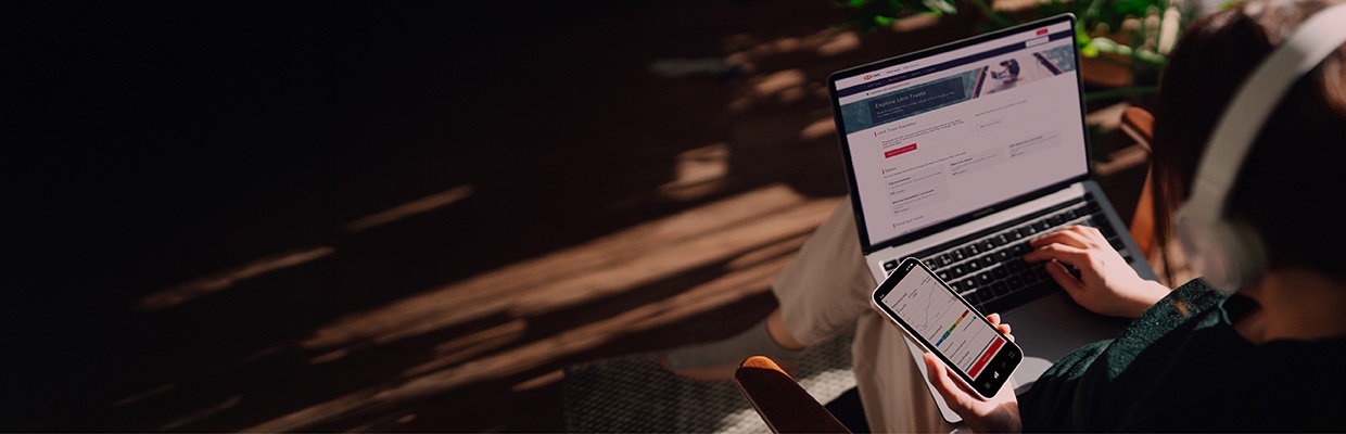 A man is holding a mobile phone and a tumbler in a dining place; image used for HSBC EZInvest