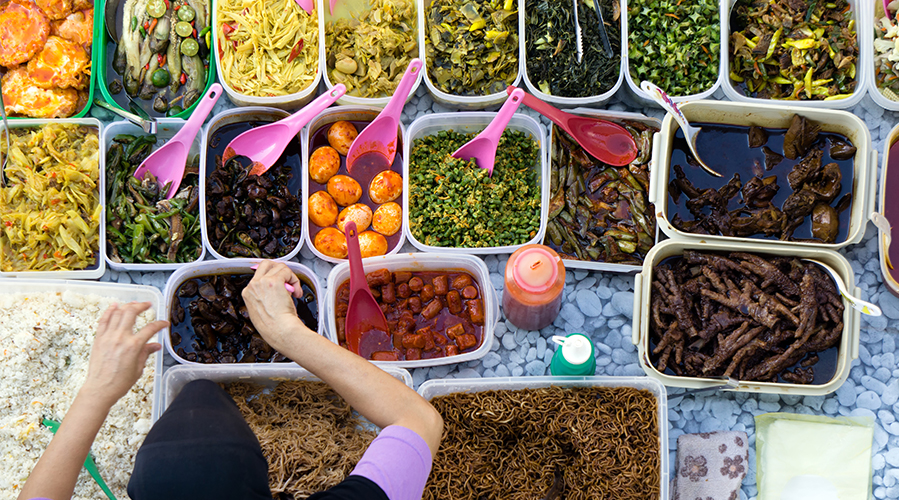 A woman with many boxes of food; image used for HSBC Malaysia Best Bazaar article