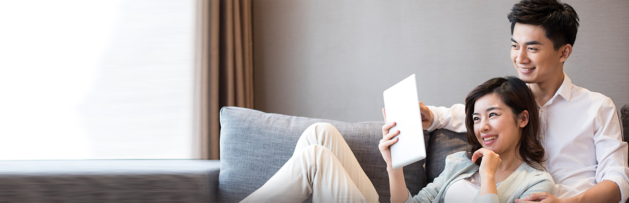 Cheerful young couple using digital tablet; image used for HSBC Malaysia HSBC time deposit account page