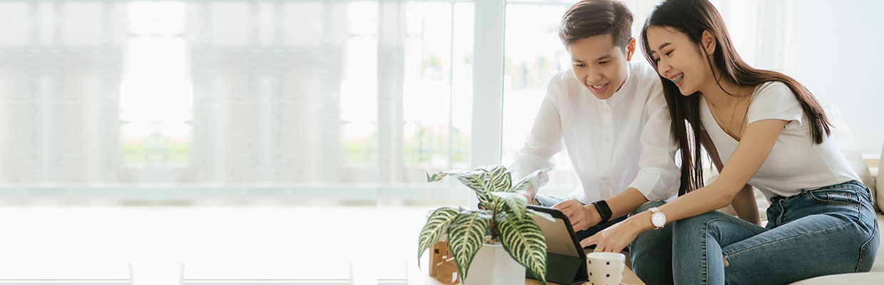 A couple is using tablet at home; image used for HSBC Malaysia digital account opening page.