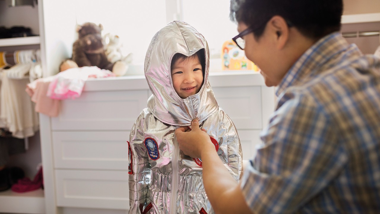 A dad is helping his son wearing his clothes; imaged used for HSBC Malaysia HSBC Advance Account page.