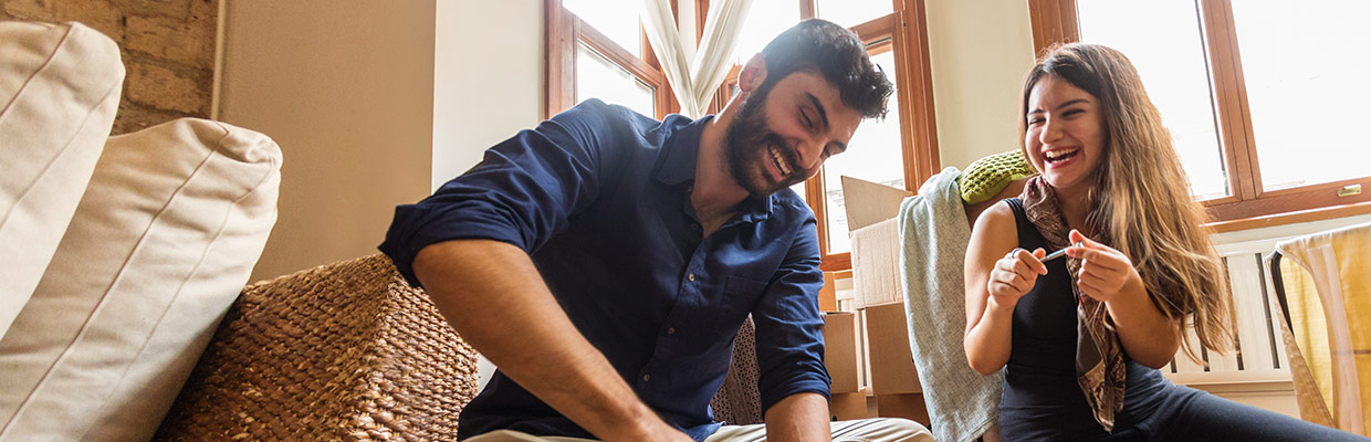 A man and woman are are laughing together while building furniture; image used on HSBC Malaysia Online and on your side page.