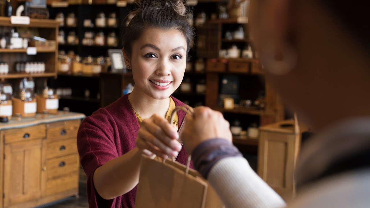 A woman receiving a shopping bag from a staff; image used for HSBC Malaysia Balance Conversion page.