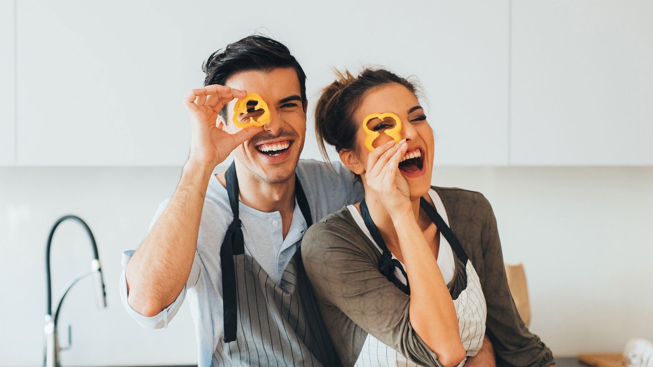 The couple wearing the apron laughed in the kitchen; images used for HSBC Amanah VIP SmartPrivileges.