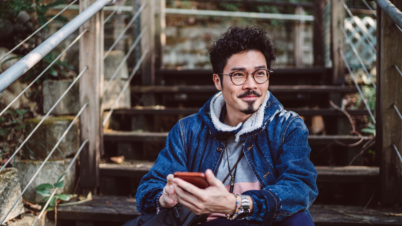 Man outside on phone; image used HSBC MY save or pay off debt article page