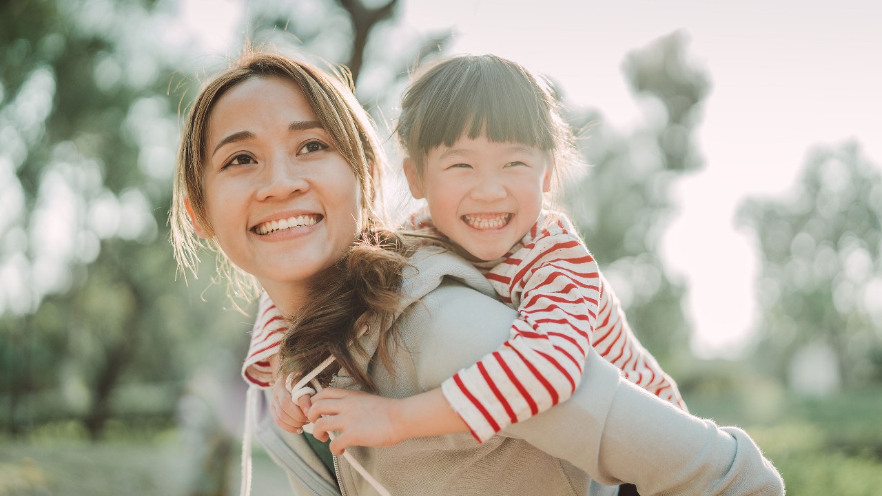 Mother is giving her daughter a piggyback; image used for HSBC Malaysia savings strategies for life article page