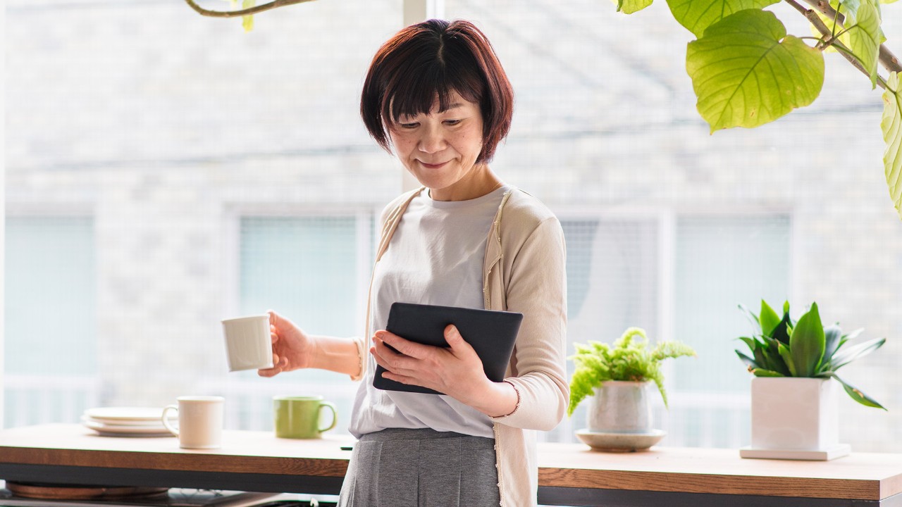 A lady reading e-book; image used for HSBC Malaysia UniversalIncome Plan page.