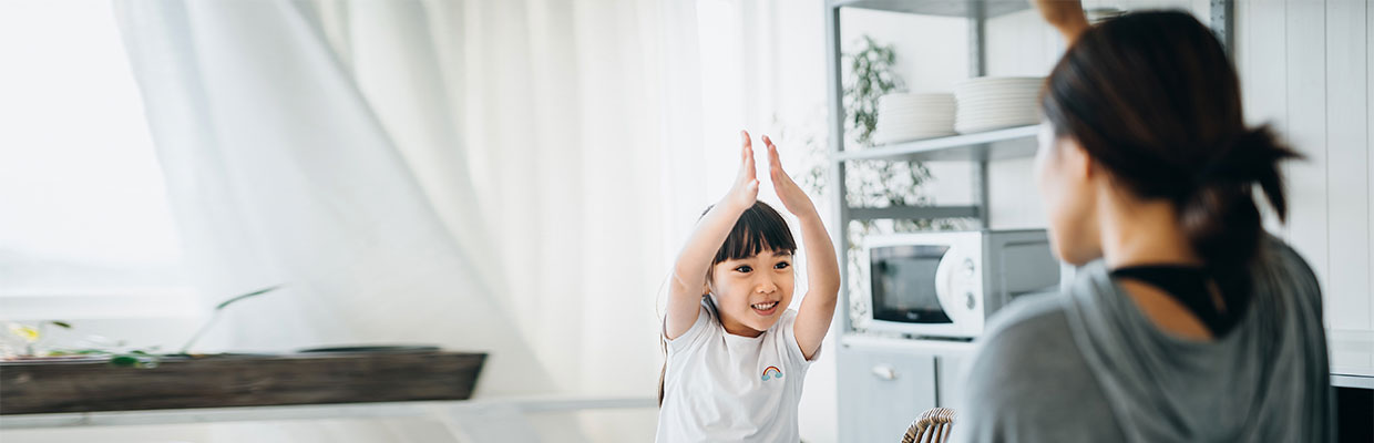 A mother and her little daughter are having fun while having breakfast together; image used on HSBC Malaysia Smart Home Cover page. 