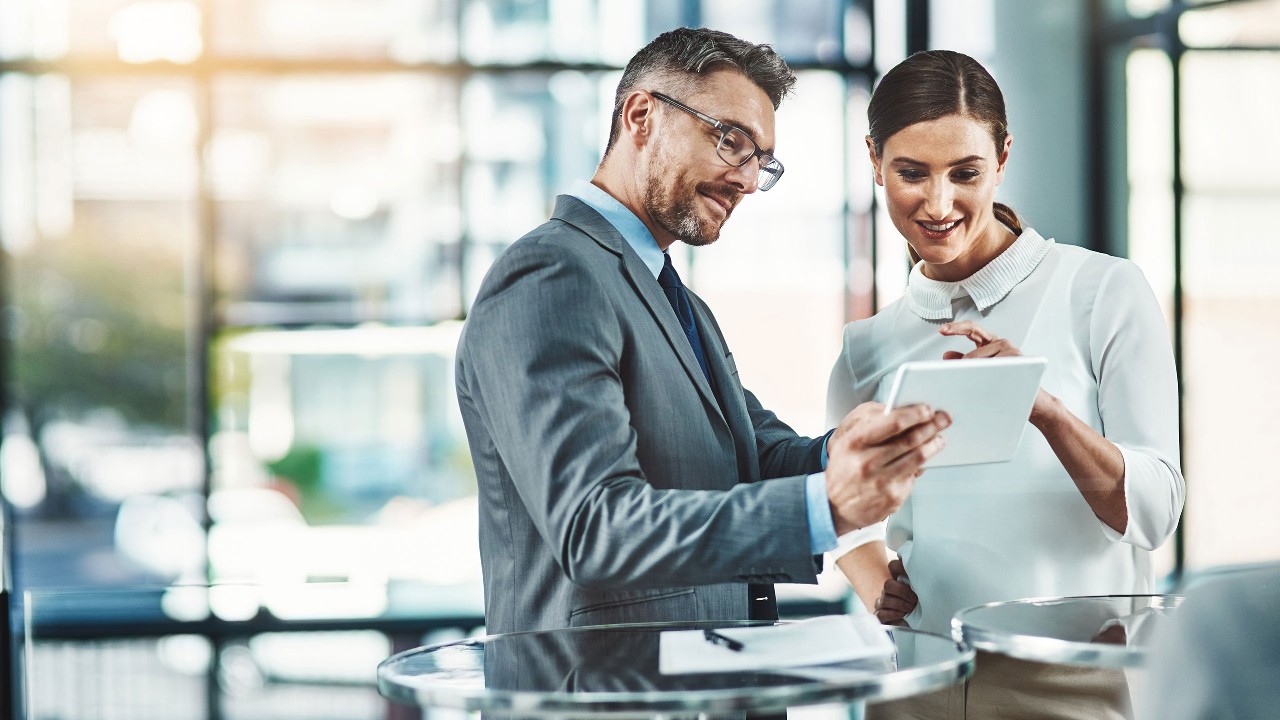 Two people in an office comparing notes. Image used for HSBC Malaysia FPX page.