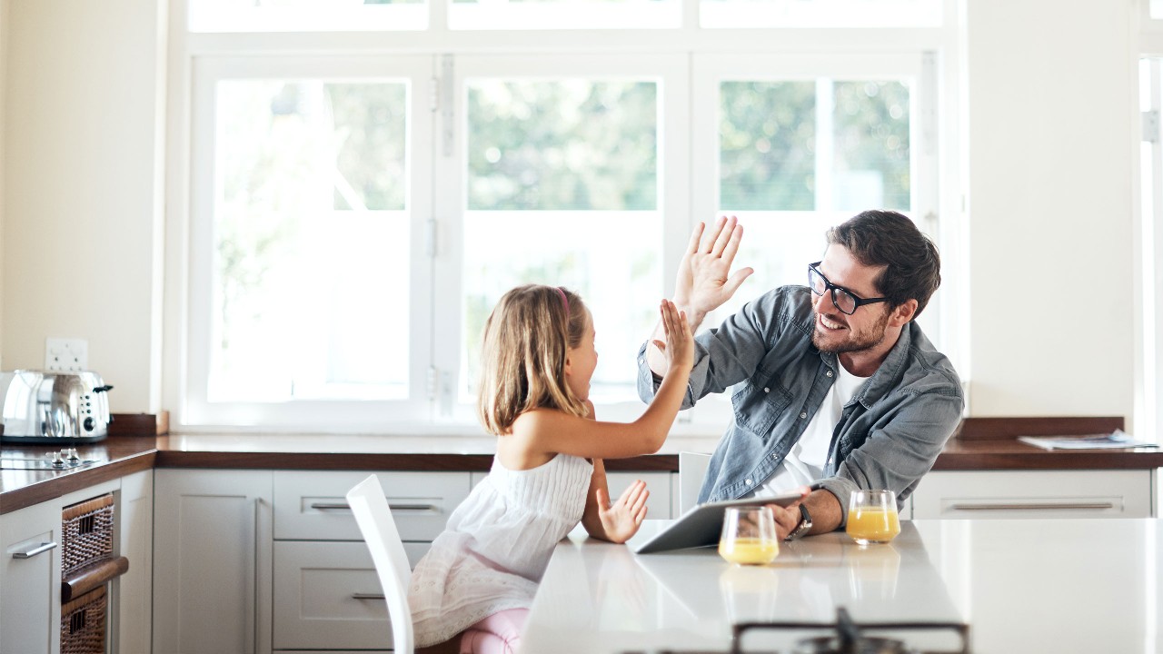 Father and daughter having breakfast and giving a high five. Image used for HSBC Malaysia Apply for a Malaysia credit card page.