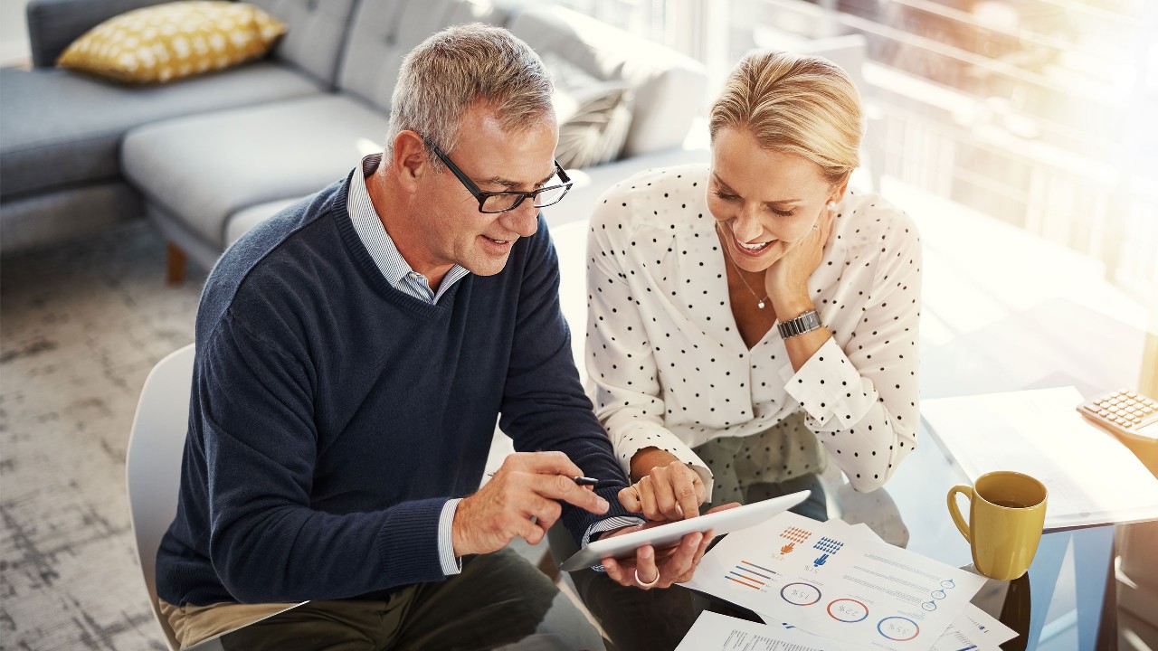 Couple with a tablet reviewing and discussing their wealth. Image used for HSBC Malaysia Wealth Solutions page.