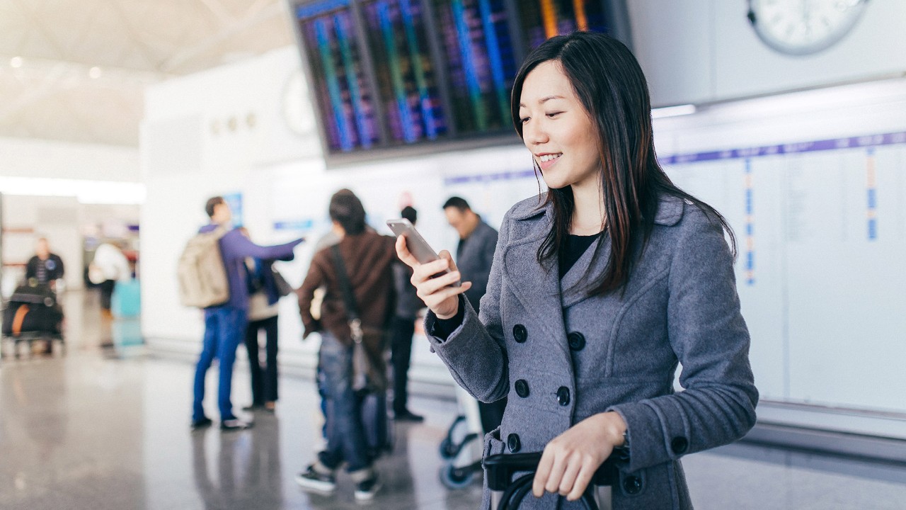 A woman is using her phone; image used for HSBC Malaysia International transfer and payment