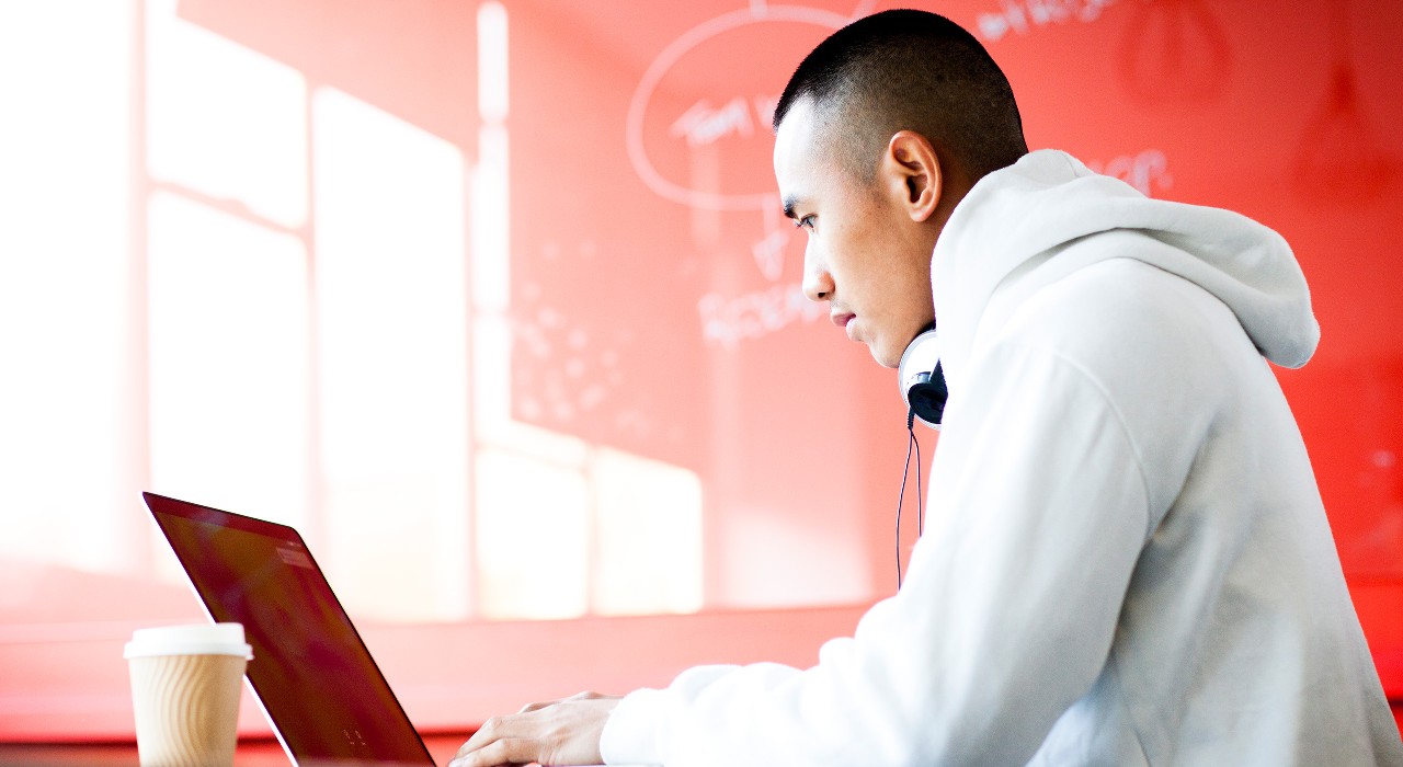 Young man working on his computer; image used for HSBC MY's Investing In The New Normal Liquid article