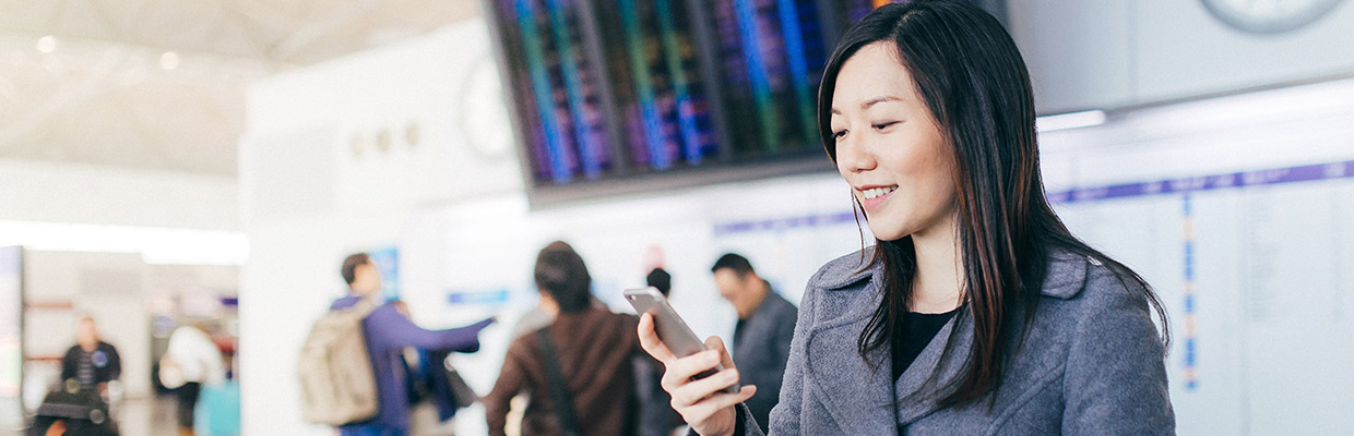 A woman is using her phone; image used for HSBC Malaysia International transfer and payment