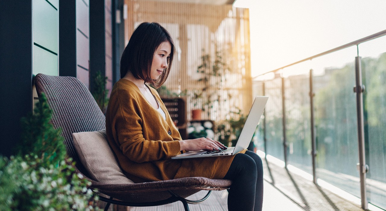 A girl is sitting on a chair and typing on her laptop; image used on HSBC Malaysia Riding the digital economy boom article page.