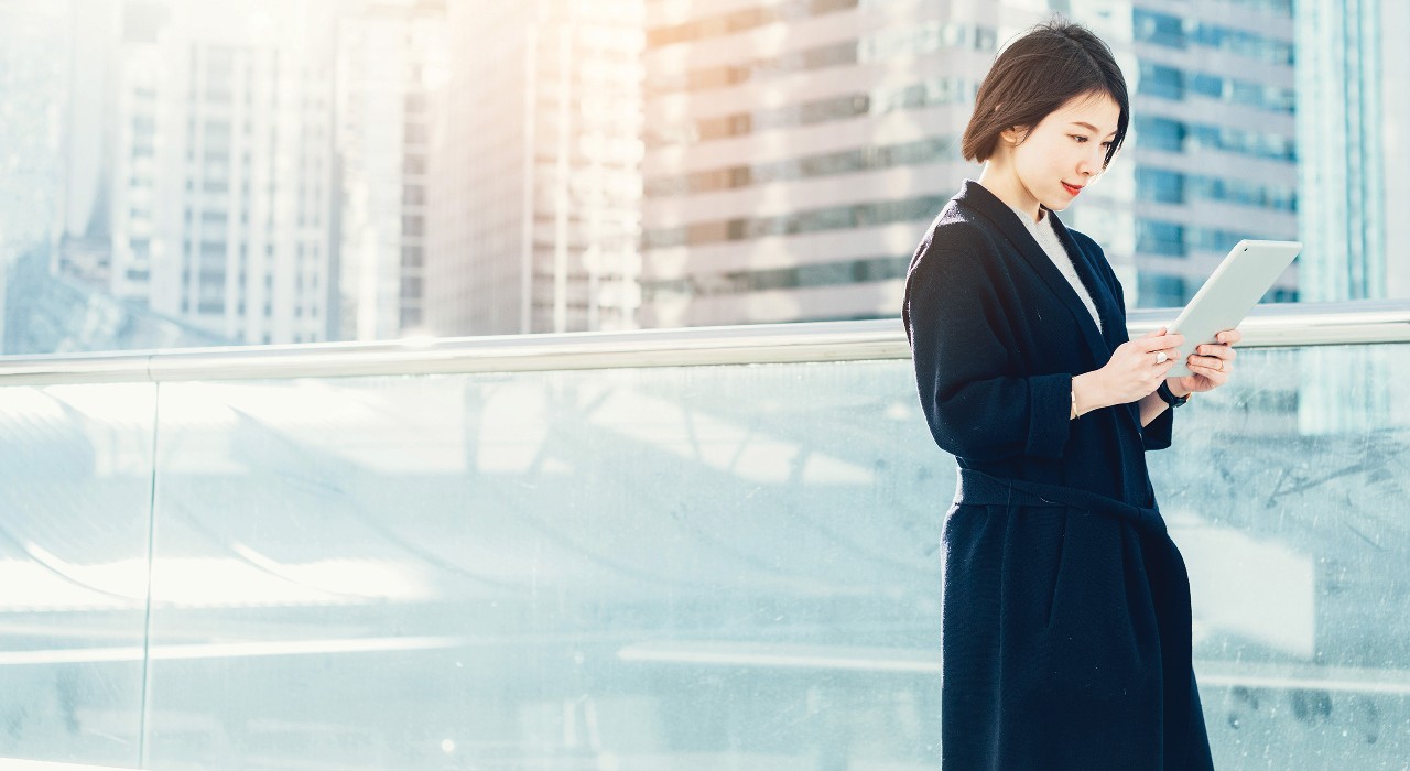 Woman using tablet outside; image used for HSBC Malaysia's Investment Outlook for 2021 Liquid article page.