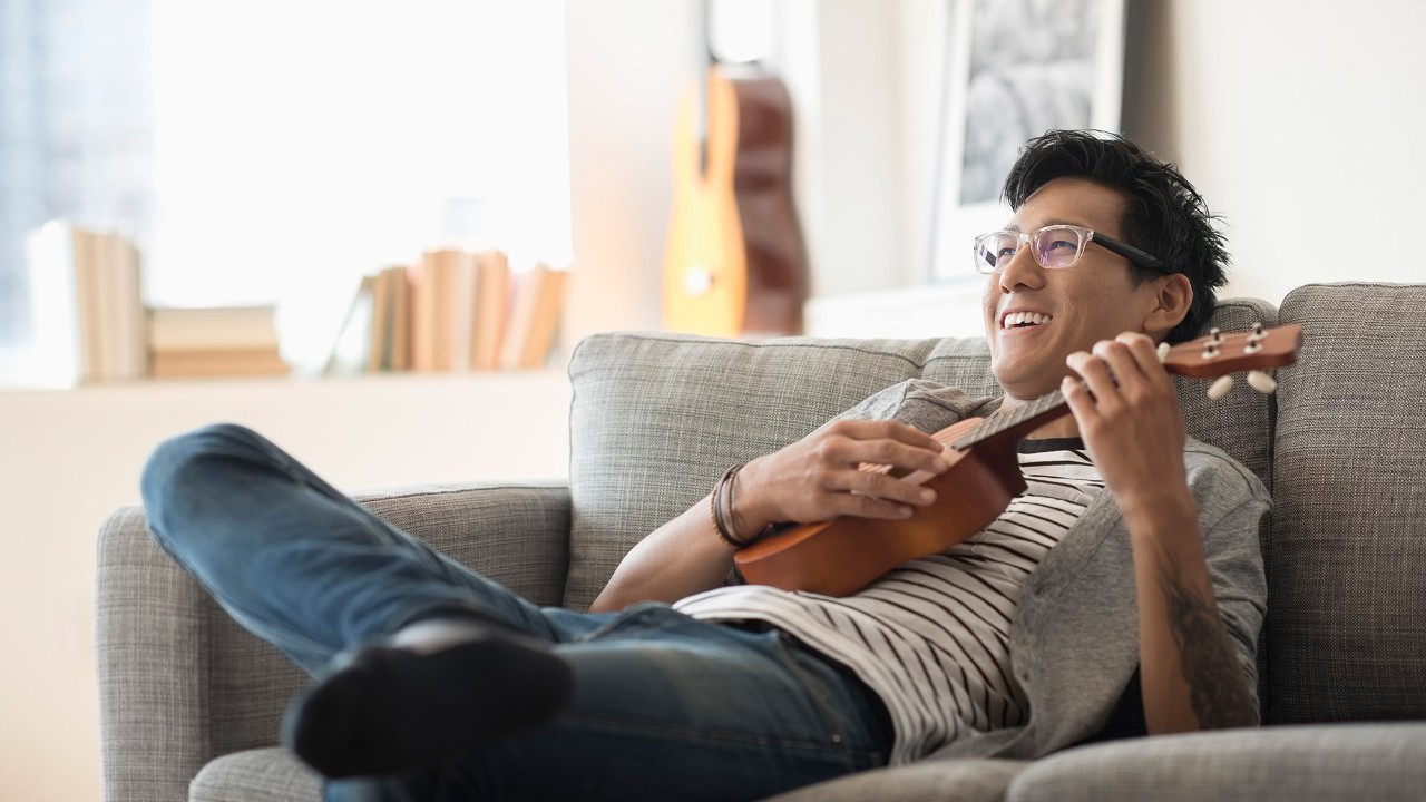 A man is playing a ukulele; image used for HSBC Malaysia Amanah Homesmart-i