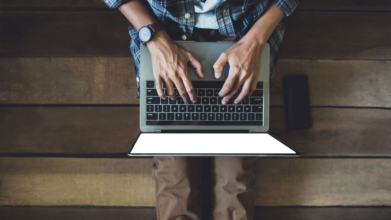 Man in casual wear typing on a laptop; image used for HSBC Malaysia Fusion ‘How SME owners protect the business from phishing’ article.