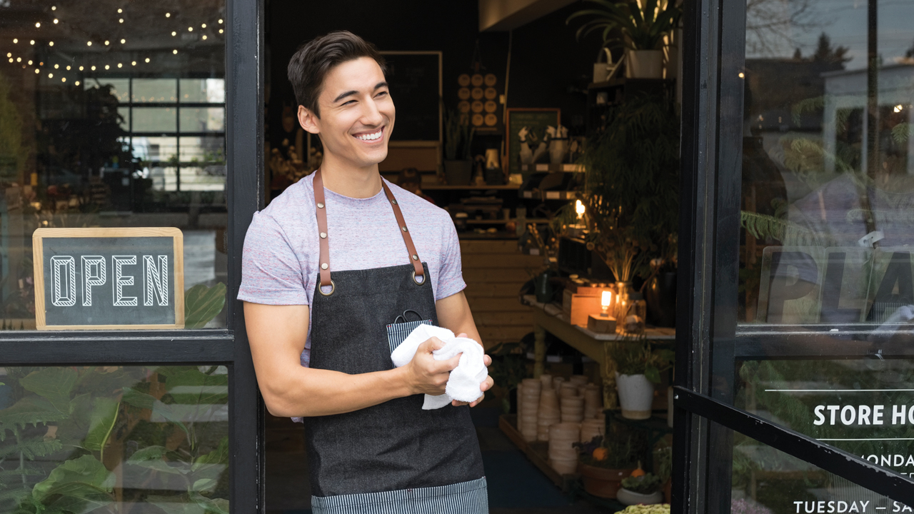 A small business owner standing in front his shop; image used for HSBC Fusion Time Deposit Account.