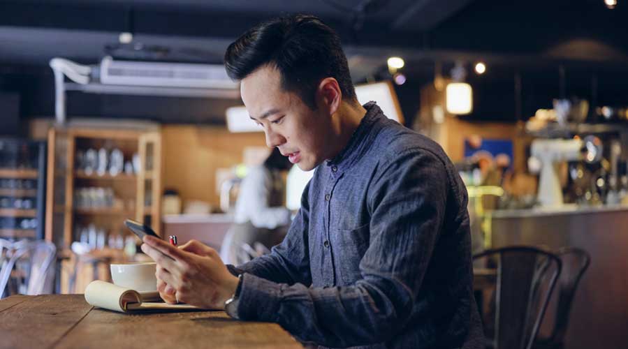 Small business owner is using his mobile; image used for HSBC Malaysia Fusion ‘Managing your SME business through COVID-19’ article. 