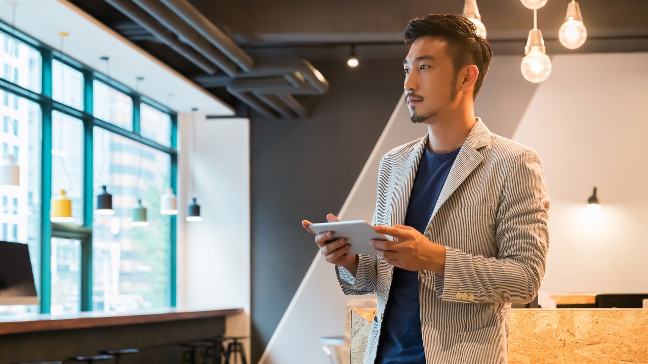 A businessman is checking his iPad in the studio; image used for HSBC Fusion Malaysia 1-Biz Account page