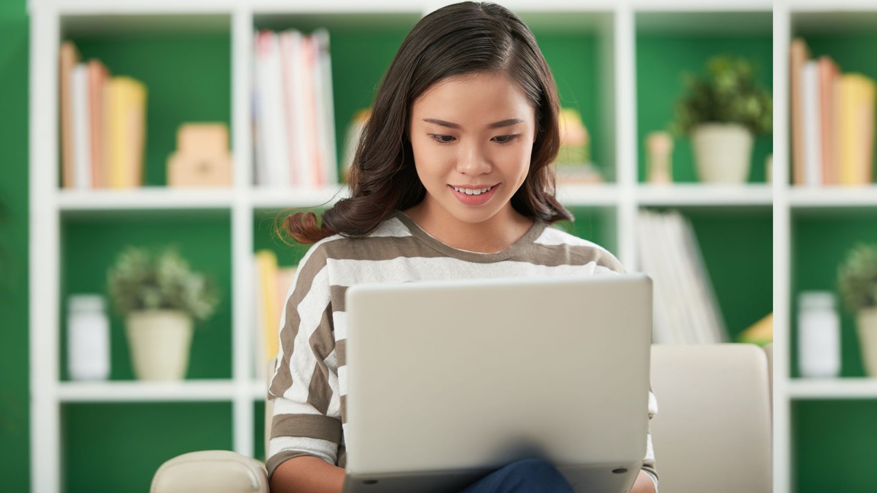 Woman using a laptop in a couch; image used for HSBC Malaysia Fusion ‘How SME owners protect the business from phishing’ article.