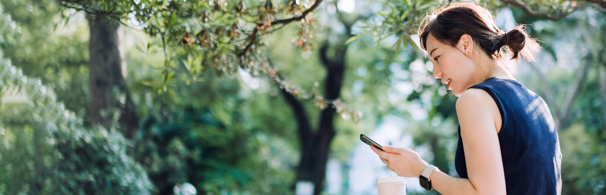 A woman is looking at her mobile phone; image used for HSBC Malaysia Fusion 'Work life balance for small business owners' article page.