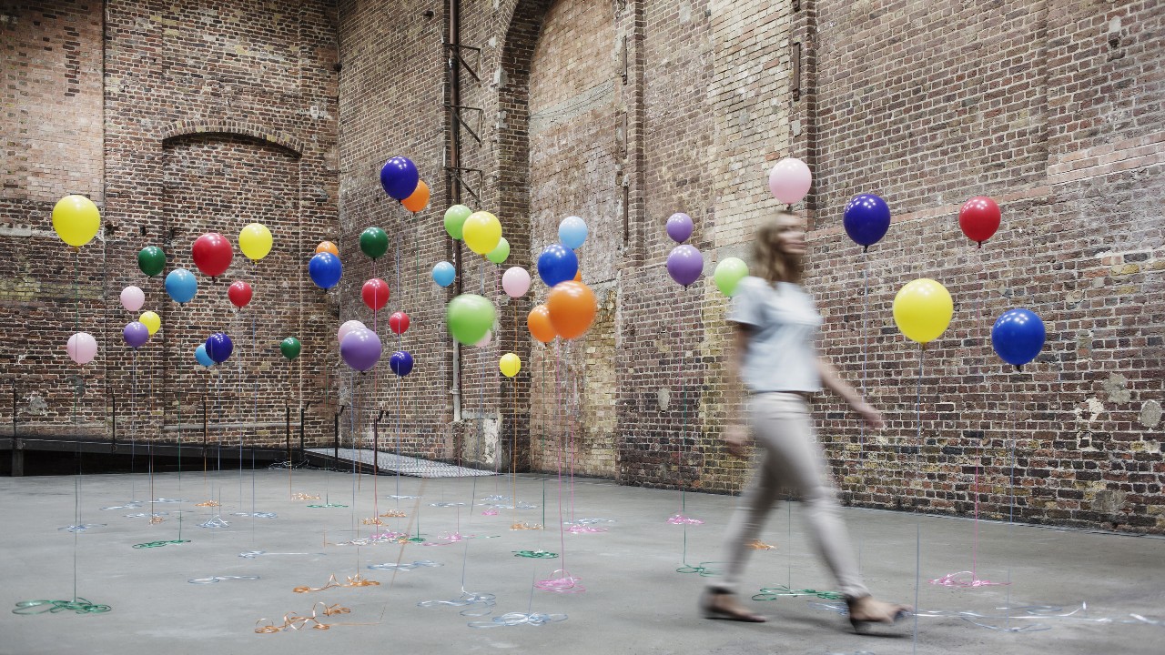 A woman is walking between balloons; image used for HSBC Malaysia Fusion 'Work life balance for small business owners' article page.